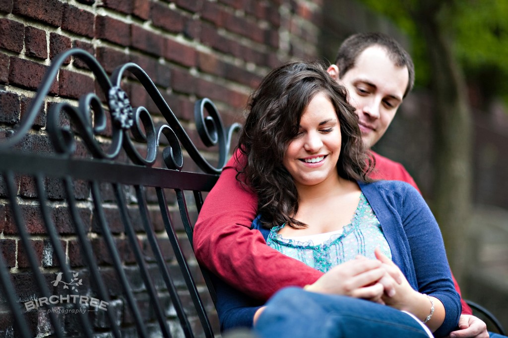 couple sitting on bench in mellon park for engagement session in pittsburgh