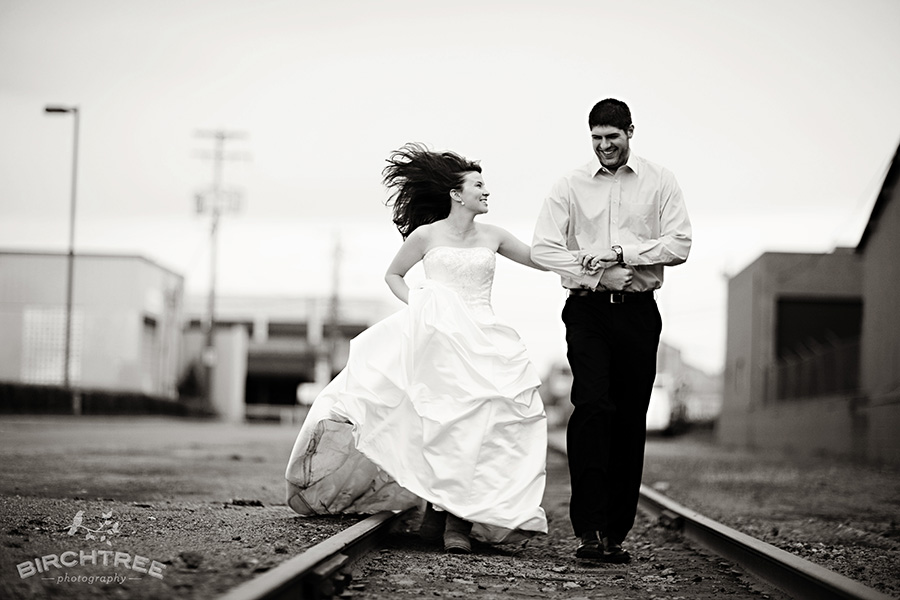 couple running down the train tracks in their wedding attire