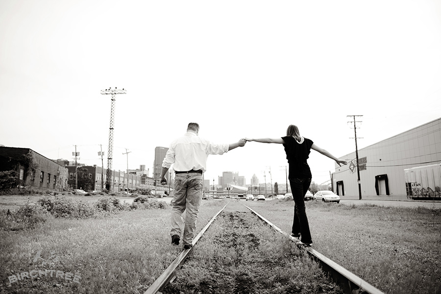 pittsburgh strip district engagement photo of couple walking along train tracks