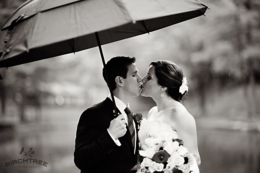 bride and groom kiss under umbrella in the rain in pittsburgh