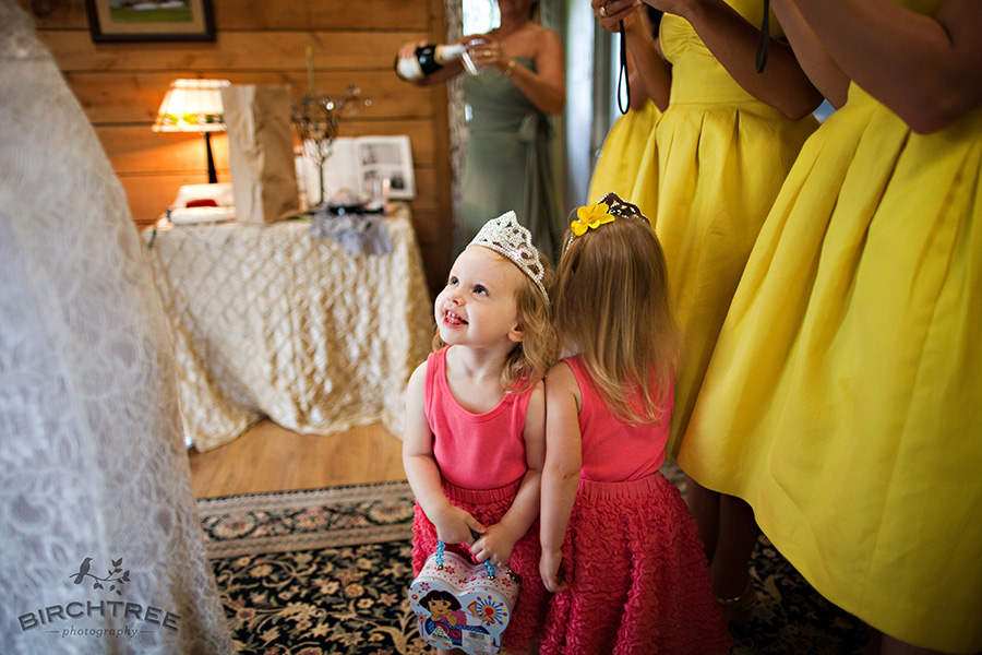 flower girl gazing at bride after she puts her dress on
