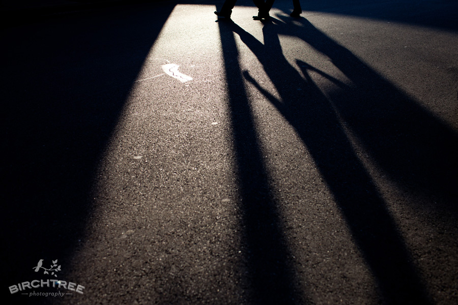 couple walking across street holding hands shadow