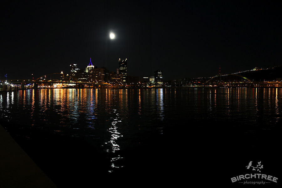 downtown pittsburgh panoramic view of the city with night lights and moon